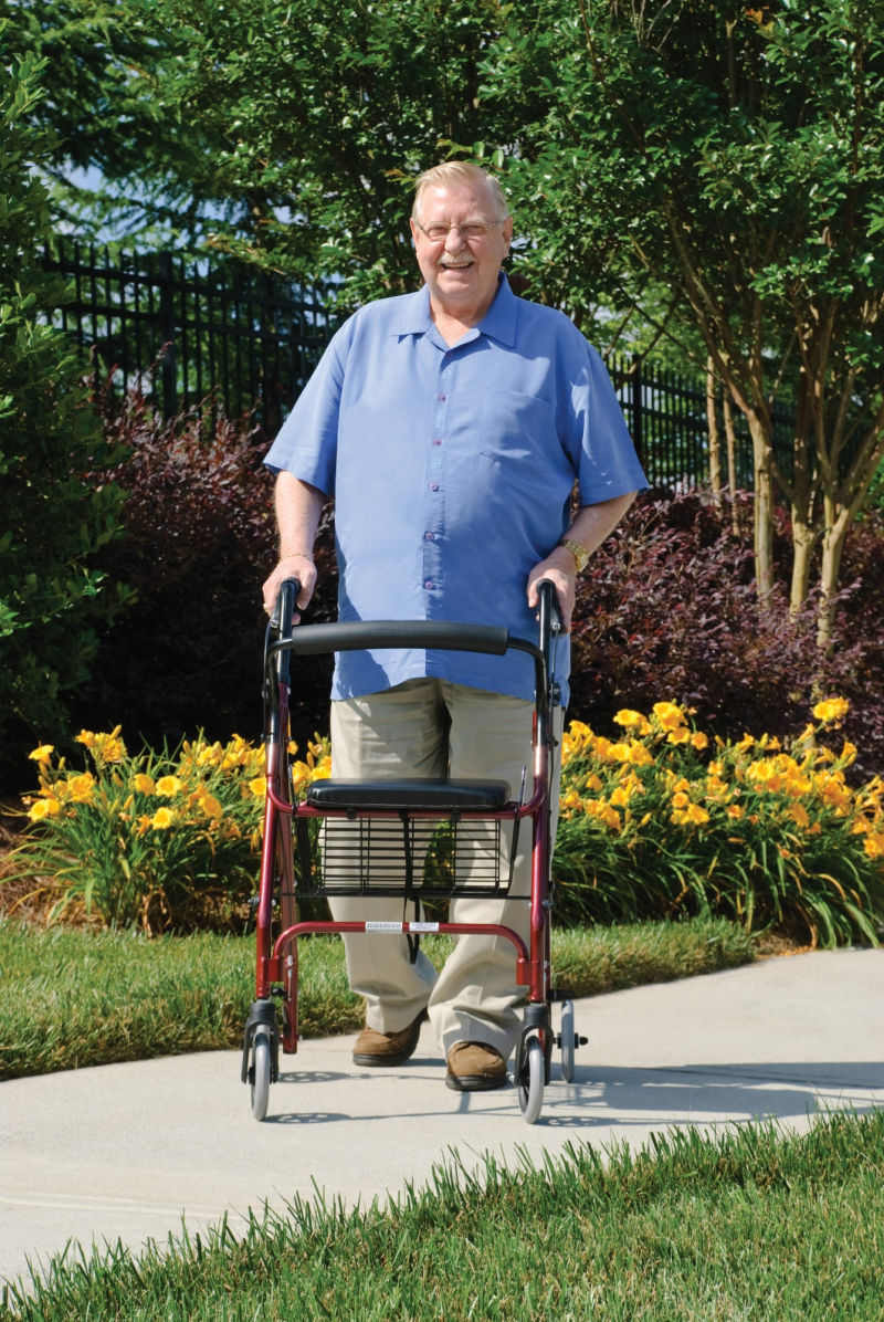 Older genterman walking with walkabout lite rollator
